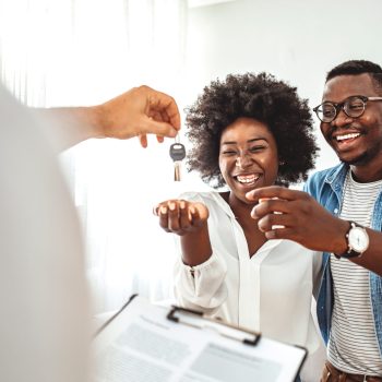 Young couple in love starting family life, got a chance of acquiring independent home ownership, given key from new apartment, social renting, purchasing new apartment, meeting with real estate agent